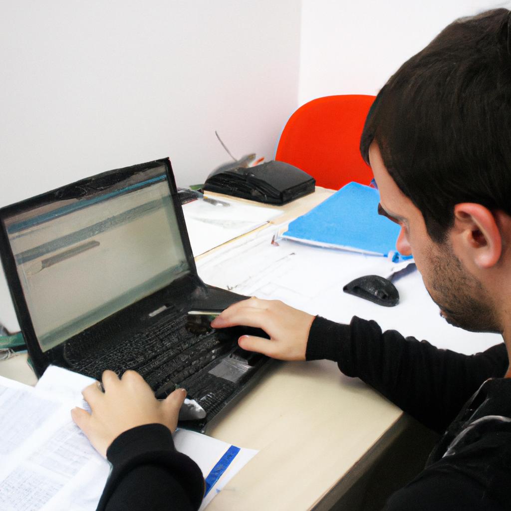Person working with computer and documents